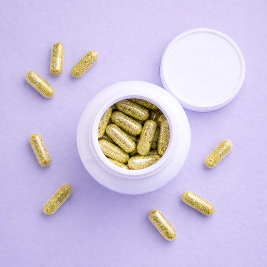 Gold capsules of Balance by ARYA Lab around a white container on a purple background