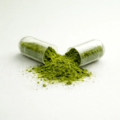 One capsule of Glow by ARYA LAB with green powder spilling out on a white background